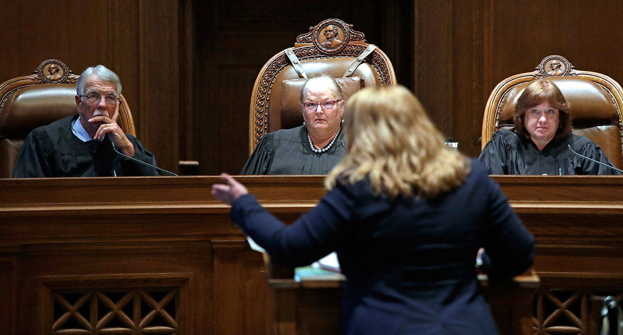 Justice Charles Johnson, left, Chief Justice Mary Fairhurst, center, and Justice Barbara Madsen, right, listen June 11 as Michele Earl-Hubbard, an attorney for a media coalition led by The Associated Press and Sound Publishing, speaks during a hearing before the state Supreme Court in Olympia regarding a case that will determine whether state lawmakers are subject to the same disclosure rules that apply to other elected officials under the voter-approved Public Records Act. (Elaine Thompson/The Associated Press, File)