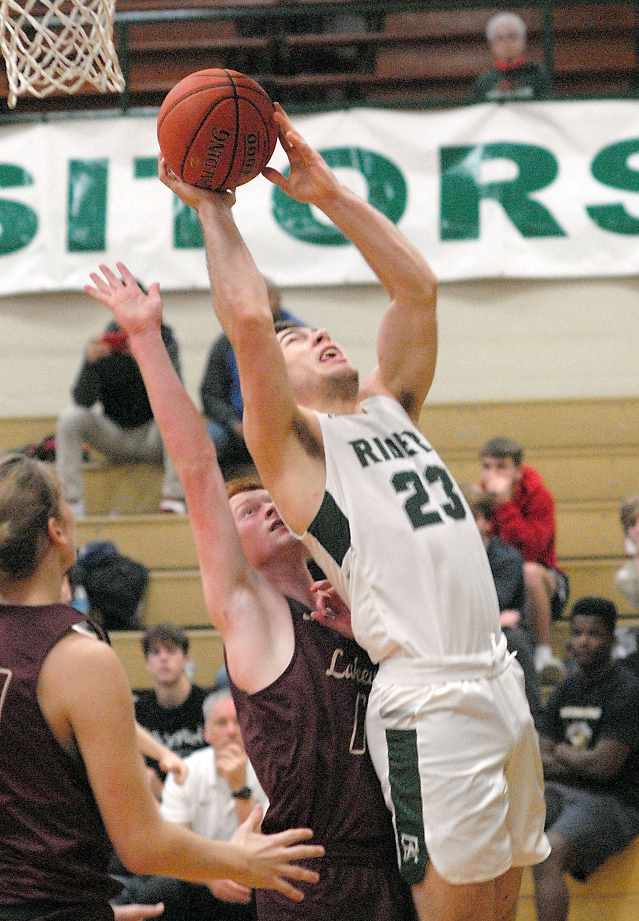Port Angeles Anton Kathol stretches up for shot over Lakewoods Alex Jensen as Lakewoods Blake Conyers, left, looks on during Saturdays game at Port Angeles High School. (Keith Thorpe/Peninsula Daily News)