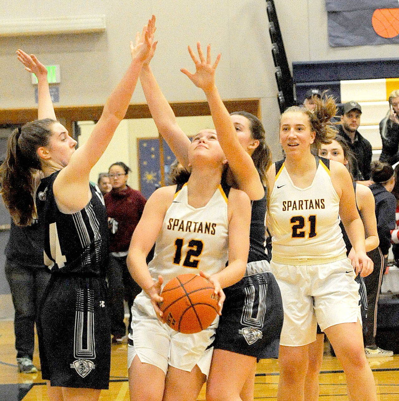 Lonnie Archibald/for Peninsula Daily News Spartan Kray Horton (12) looks to shoot against Kings Way Christian in Forks on Saturday as the Spartans won 57-54. Looking on is Hortons teammate Chloe Leverington (21).