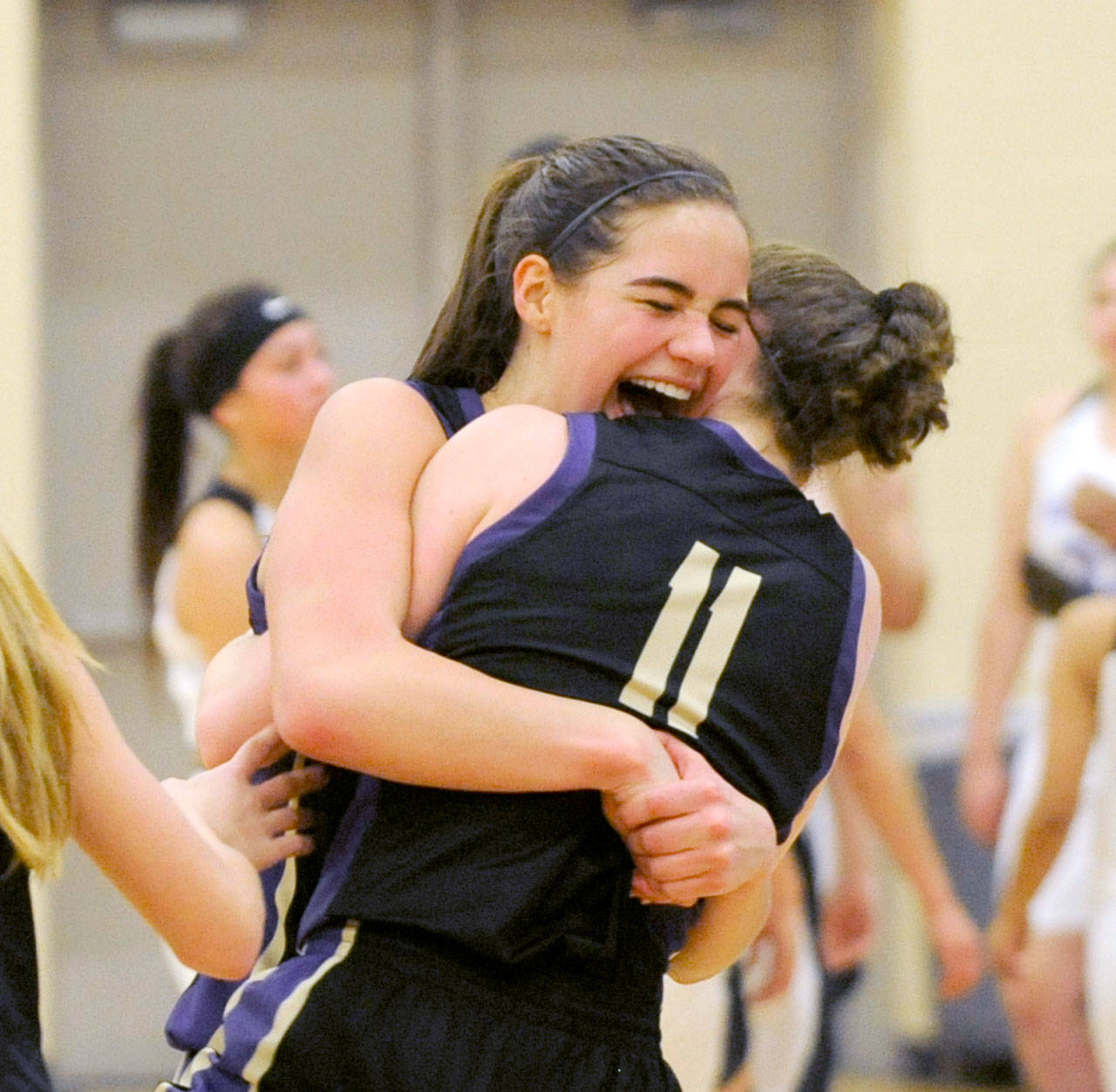 Sequims Hope Glasser, left, and Abby Schroeder celebrate the Wolves come-from-behind 54-44 victory over Foster to advance to the Class 2A State Tournament. (Michael Dashiell/Olympic Peninsula News Group)