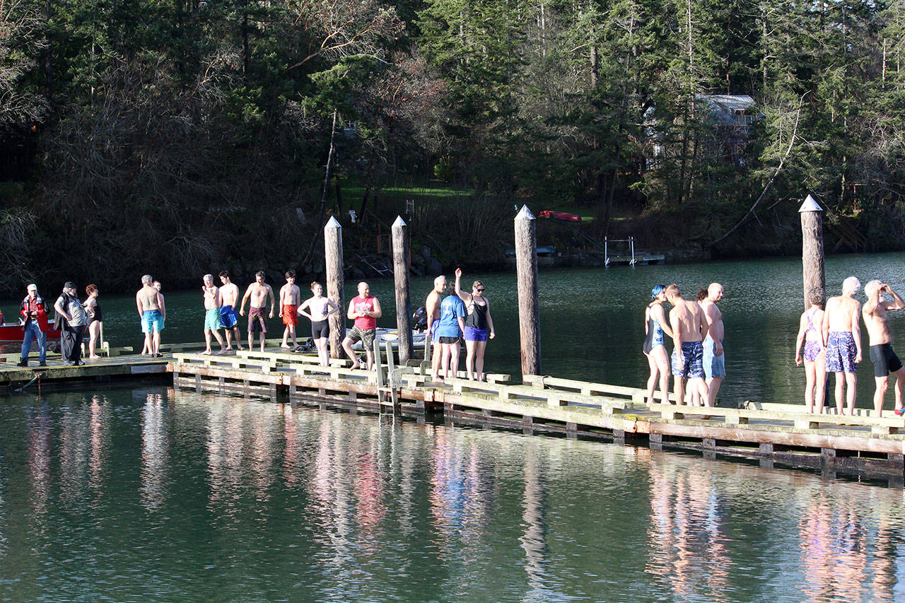 Jumpers line the dock in front of the Nordland General Store as they prepare to leap into the water to celebrate the new year as part of the Nordland Polar Plunge. (Zach Jablonski/Peninsula Daily News)