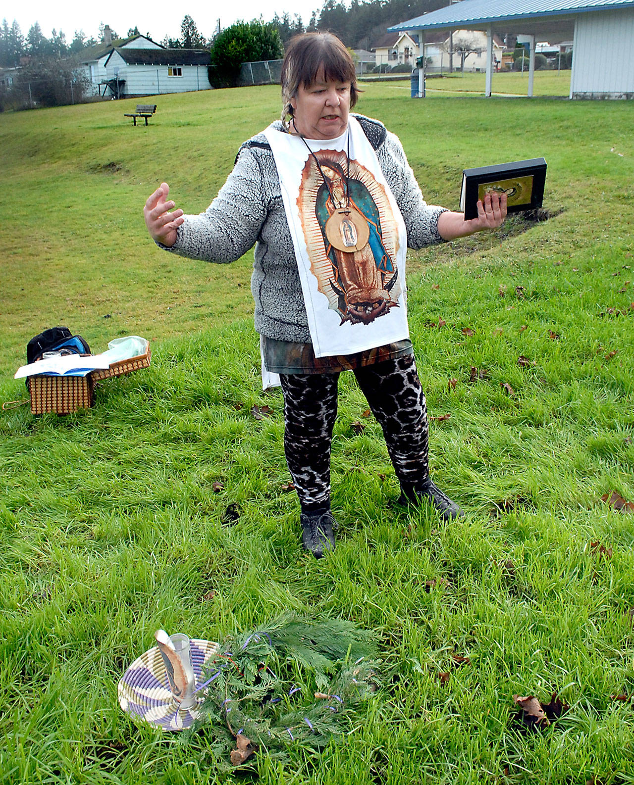 Devon Gray of Port Angeles eulogizes the felling of a beloved sequoia tree after placing a wreath and a candle where the tree once stood on Friday in Lions Park in Port Angeles. (Keith Thorpe/Peninsula Daily News)