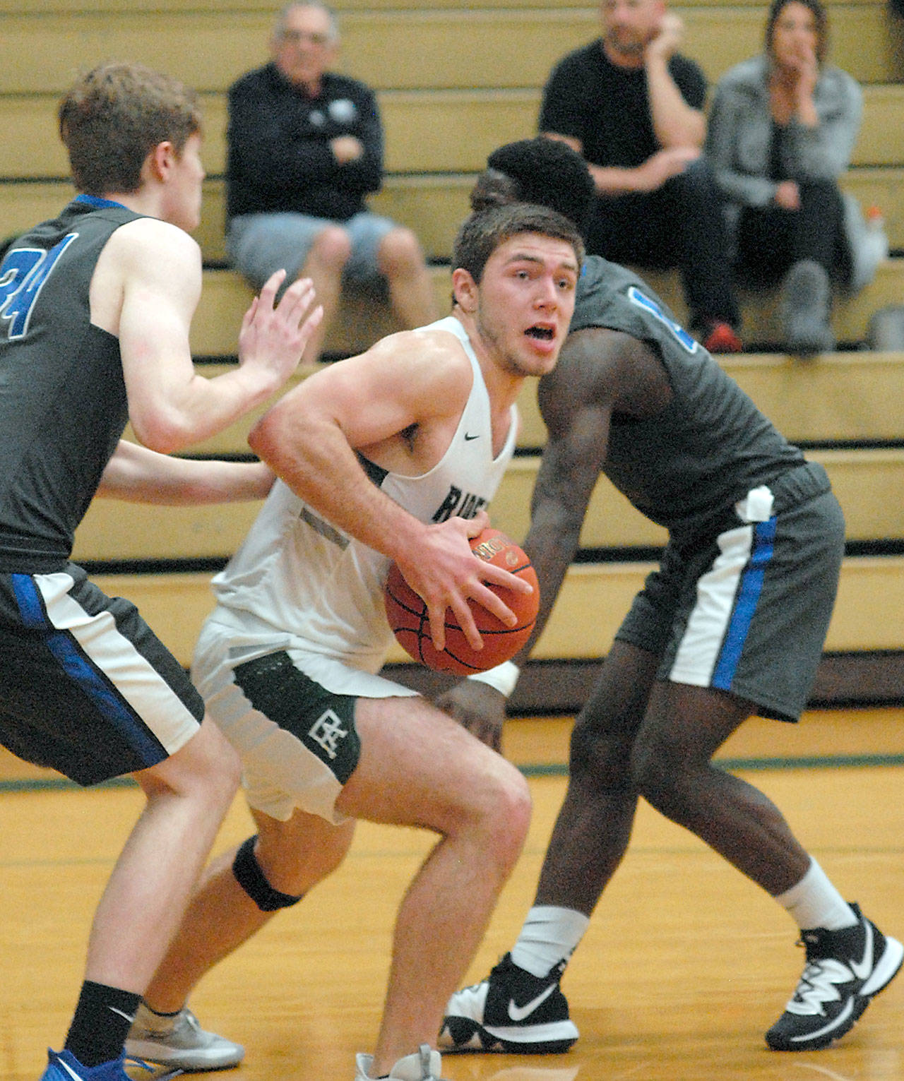 Port Angeles’ Anton Kathol, center, looks for a way around the defense of Olympic’s Caleb Erickson, left, and Kendall McInnis on Tuesday night at Port Angeles High School. (Keith Thorpe/Peninsula Daily News)