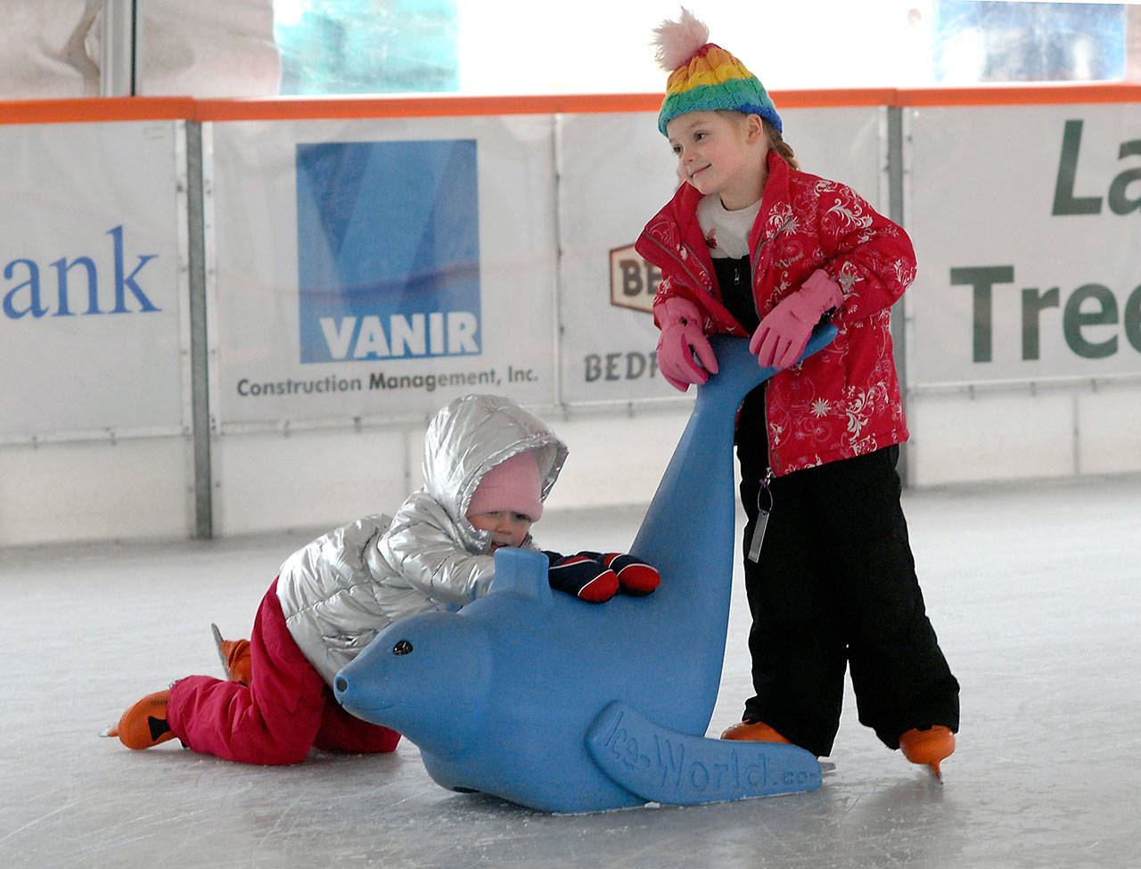 Siblings Meredith Davenport, 5, left, and Nora Davenport, 6, both of Yuba City, Calif., try their hand at ice skating Wednesday at the Winter Ice Village in downtown Port Angeles. (Keith Thorpe/Peninsula Daily News)