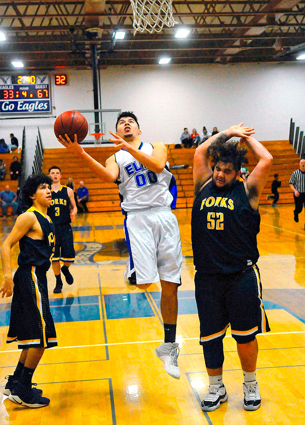 Elma’s Jesus Torres, center, drives the lane while defended by Forks’ Tony Flores, left, and Iziah Morton, right during a 2018 game. The Forks Booster Club will raffle off a gift basket to benefit Torres, an Elma senior who is battling leukemia, at Friday’s game in Forks. (Hasani Grayson/Grays Harbor News Group)
