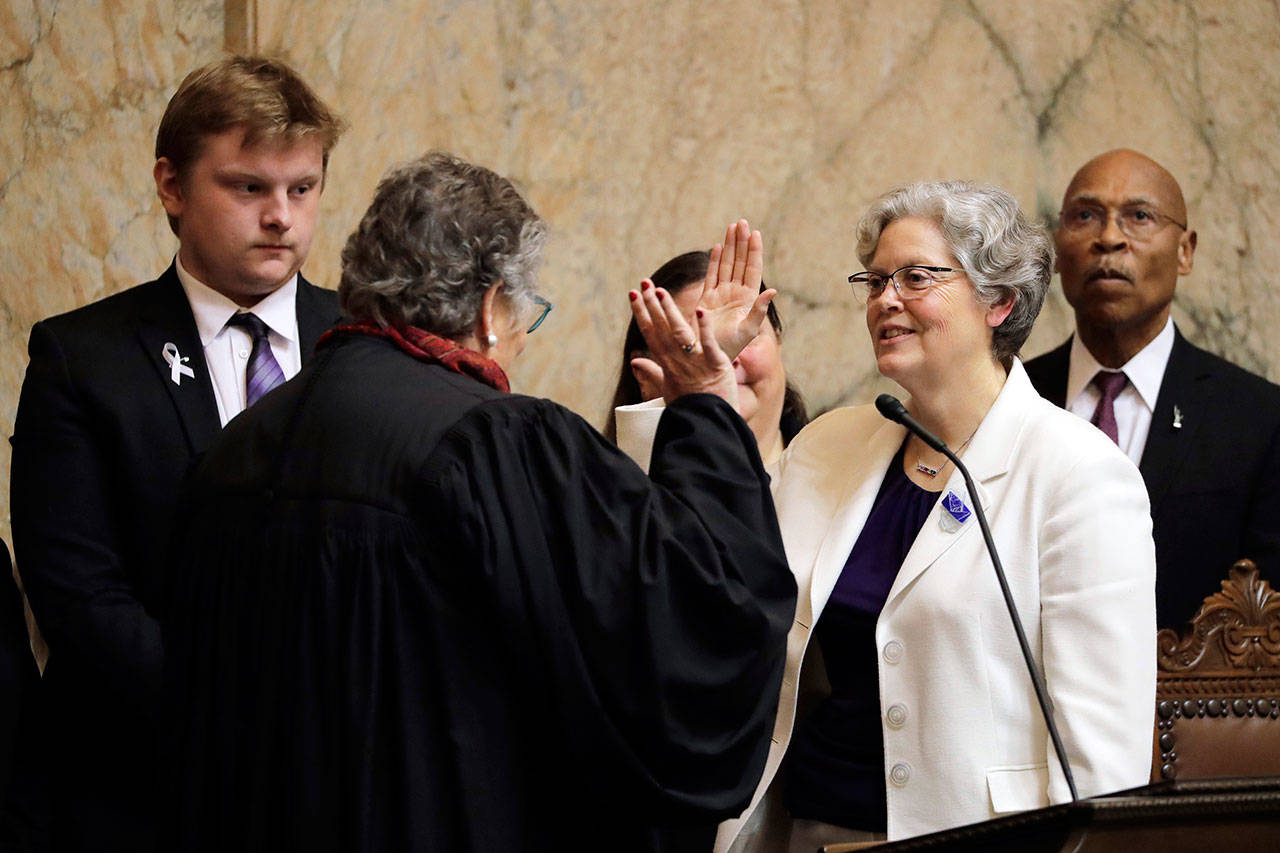 House Speaker Laurie Jinkins, D-Tacoma, second from right, is sworn in by former Washington Supreme Court Chief Justice Mary Fairhurst, second from left, Monday, on the first day of the 2020 session of the Washington legislature at the Capitol in Olympia. (Ted S. Warren/The Associated Press)
