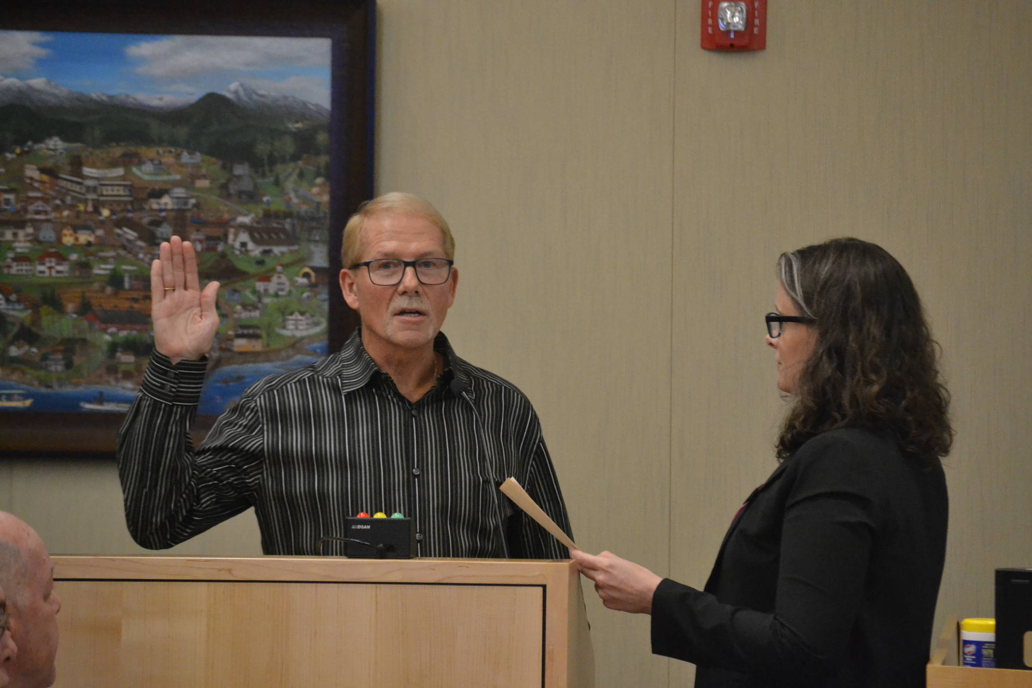 William Armacost is sworn into office Monday by Sequim City Clerk Sara McMillon. He was also elected mayor by fellow city council members. (Matthew Nash/Olympic Peninsula News Group)