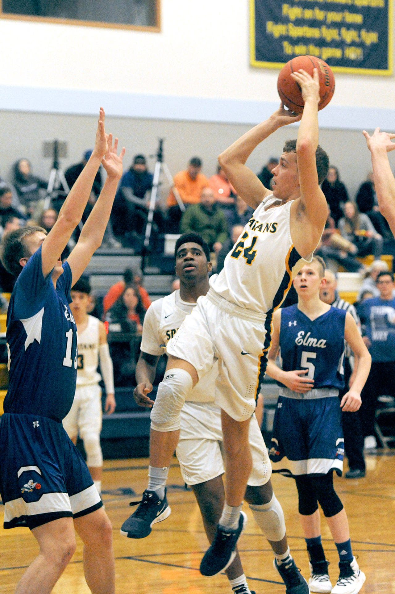 Lonnie Archibald/for Peninsula Daily News                                Forks’ Logan Olson shoots over an Elma defender Friday evening in Forks where the Eagles defeated the Spartans 49-42.