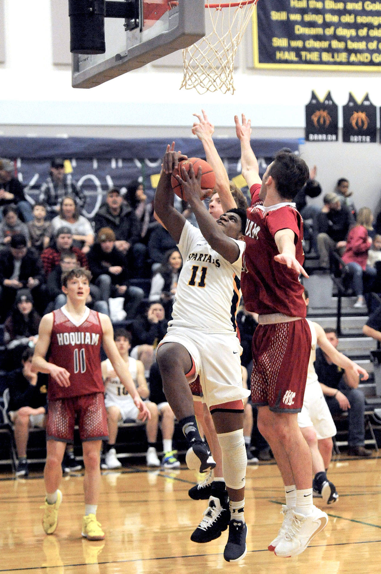 Forks’ Trey Baysinger powers his way to the basket among Hoquiam defenders Tuesday in Forks. The Spartans beat the Grizzlies 71-57. (Lonnie Archibald/for Peninsula Daily News)