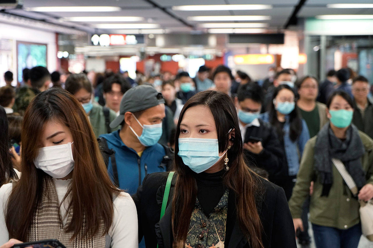 Passengers wear masks to prevent an outbreak of a new coronavirus in a subway station, in Hong Kong, Wednesday, Jan. 22, 2020. The first case of coronavirus in Macao was confirmed on Wednesday, according to state broadcaster CCTV. The infected person, a 52-year-old woman, was a traveller from Wuhan. (Kin Cheung/Associate Press)