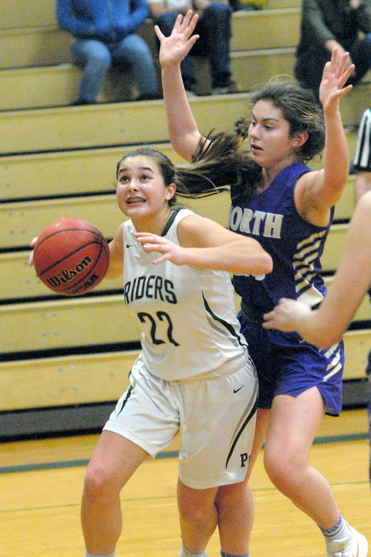 Keith Thorpe/Peninsula Daily News Port Angeles’ Eve Burke, left, drives to the lane as North Kitsap’s Elizabeth Kimmel defends on Friday night in Port Angeles.