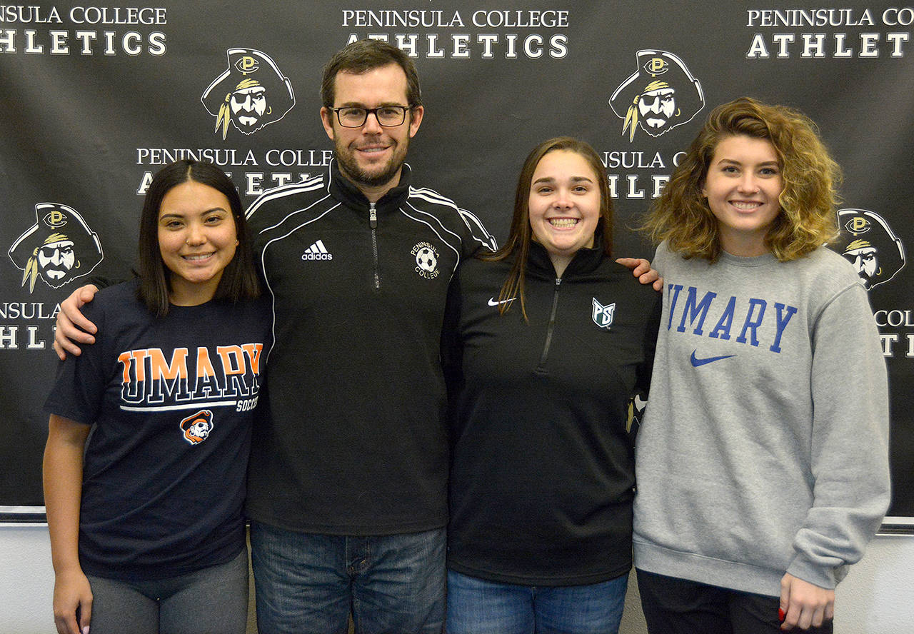 Peninsula College Athletics Peninsula College women’s soccer players Kayla Alcott (left), Sam Oliveira and Halle Nottage were joined by head coach Kanyon Anderson at a signing ceremony on Friday. The three players will move on to play at four-year schools next fall.