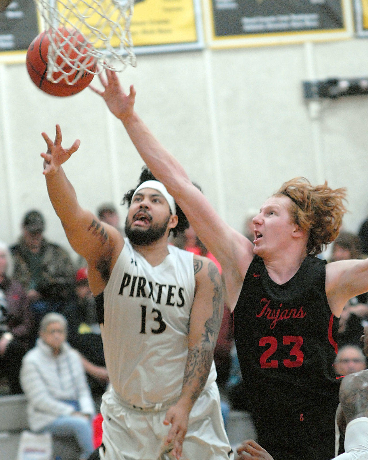 Keith Thorpe/Peninsula Daily News Peninsulas Marquis Gurske, left, goes for a shot as Everetts Devin Smith tries to deflect during Saturday nights matchup at Peninsula College in Port Angeles.