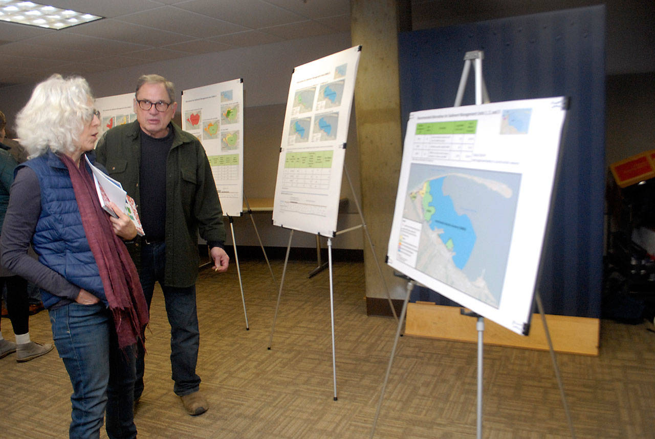Julia Smith and Rick Head of rural Port Angeles look over charts depicting industrial contamination in Port Angeles Harbor on Tuesday, Jan. 28, 2020, at Olympic Medical Center in Port Angeles. (Keith Thorpe/Peninsula Daily News)