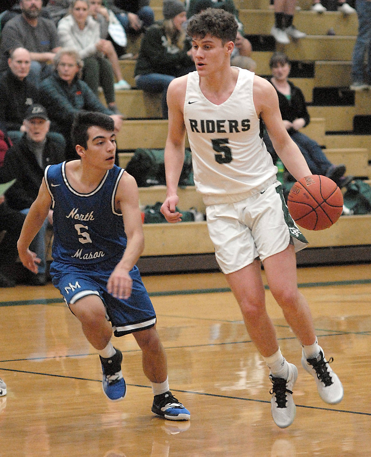 Port Angeles’ Chase Cobb, right, slips past North Mason’s Reid Williams on Tuesday night in Port Angeles. (Keith Thorpe/Peninsula Daily News)
