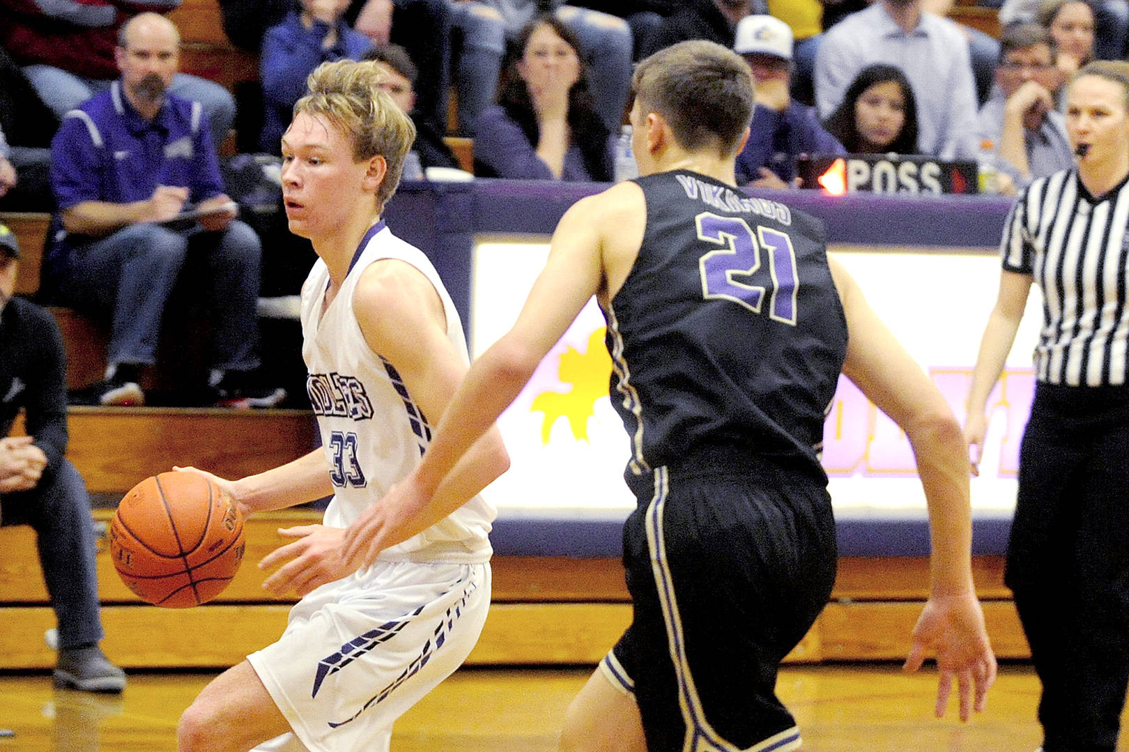 Conor Duncan/Olympic Peninsula News Group Stew Duncan (33) of Sequim brings the ball up the court against North Kitsaps Logan Chmielewski (21) on Friday night in Sequim.