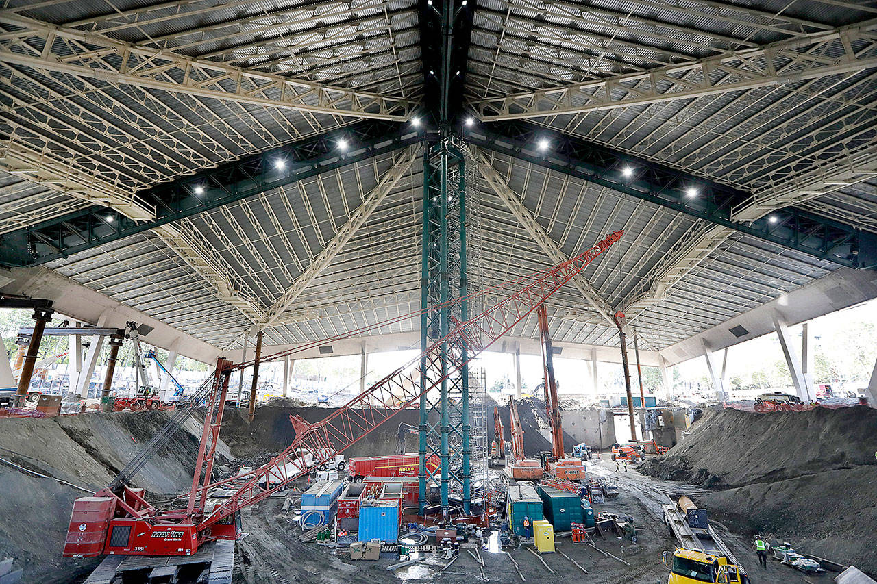 In this Sept. 16, 2019, file photo, the interior of the existing roof of KeyArena, the only part of the structure that will remain during a major renovation of the building, stands above the construction site below of what will be NHL hockey team site during a tour for media members at the Seattle Center in Seattle. Scouts for Seattle’s expansion NHL franchise have become a common sight at arenas around the league. Elaine Thompson/The Associated Press file)