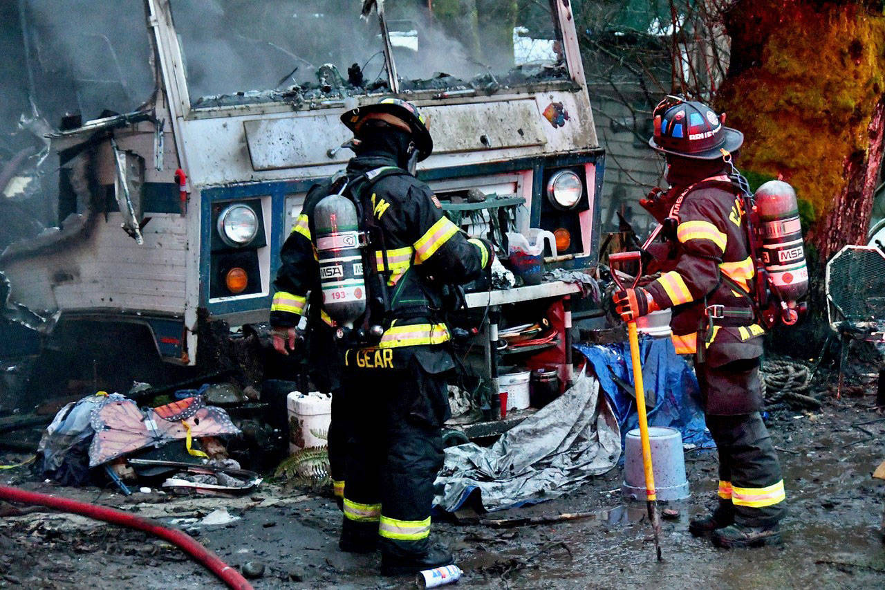 Clallam 2 Fire Rescue firefighters assess the damage to an RV that had been engulfed in flames on Old Deer Park Road near Port Angeles on Tuesday. (Clallam 2 Fire Rescue)