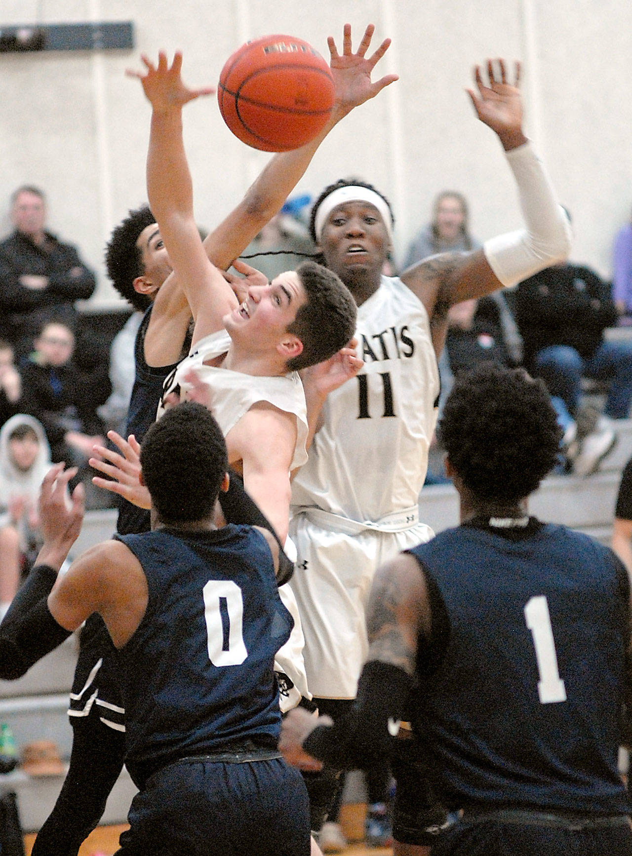 Peninsula’s Nate DeSpain, center left, and Malik Moore, center right, fight for a rebound surrounded by Bellevue defenders Trey Lawrence, back, Trevon Richmond, front left, and Tijohn Rodde, front right, on Wednesday night at Peninsula College in Port Angeles. (Keith Thorpe/Peninsula Daily News)