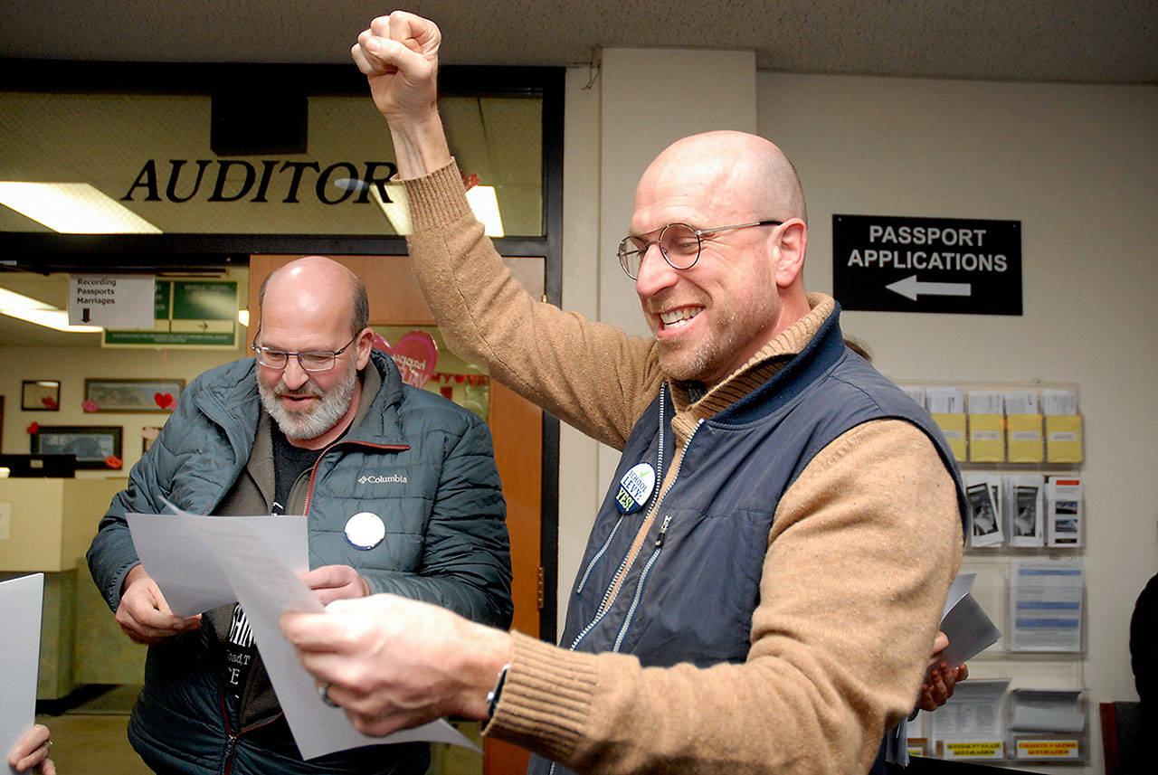 Steve Methner, committee chair for Port Angeles Citizens for Education, right, raises a fist in celebration as fellow committee member Nolan Duce looks over ballot results that showed a capital levy for the Port Angeles School District passing after Tuesday’s initial count. (Keith Thorpe/Peninsula Daily News)