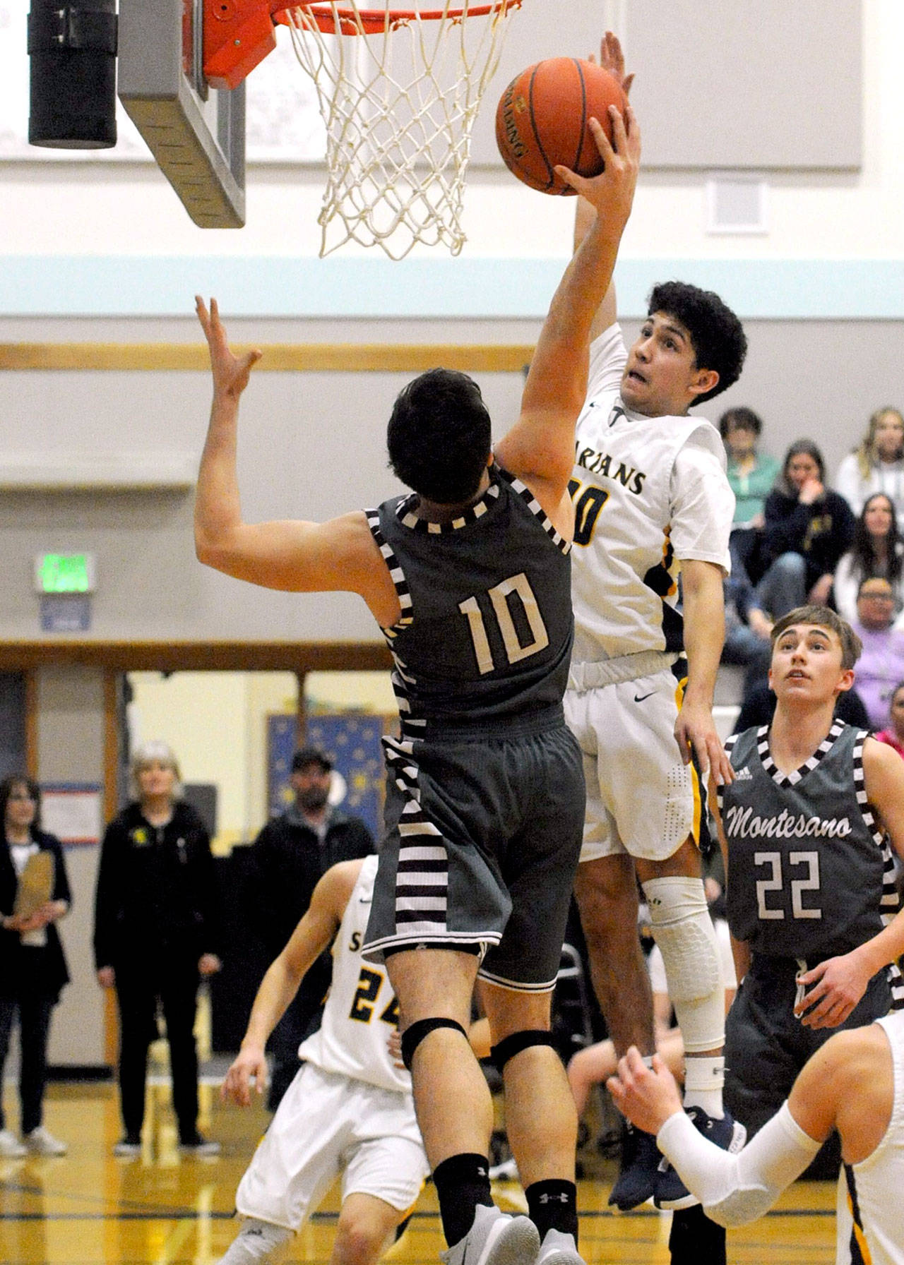 Spartan Tony Hernandez-Flores and Montesano’s Trace Ridgway go for the rebound Monday in Forks where the league leading Bulldogs came back from a 9-point deficit in the fourth quarter to defeat Forks 55-54. (Lonnie Archibald/for Peninsula Daily News)