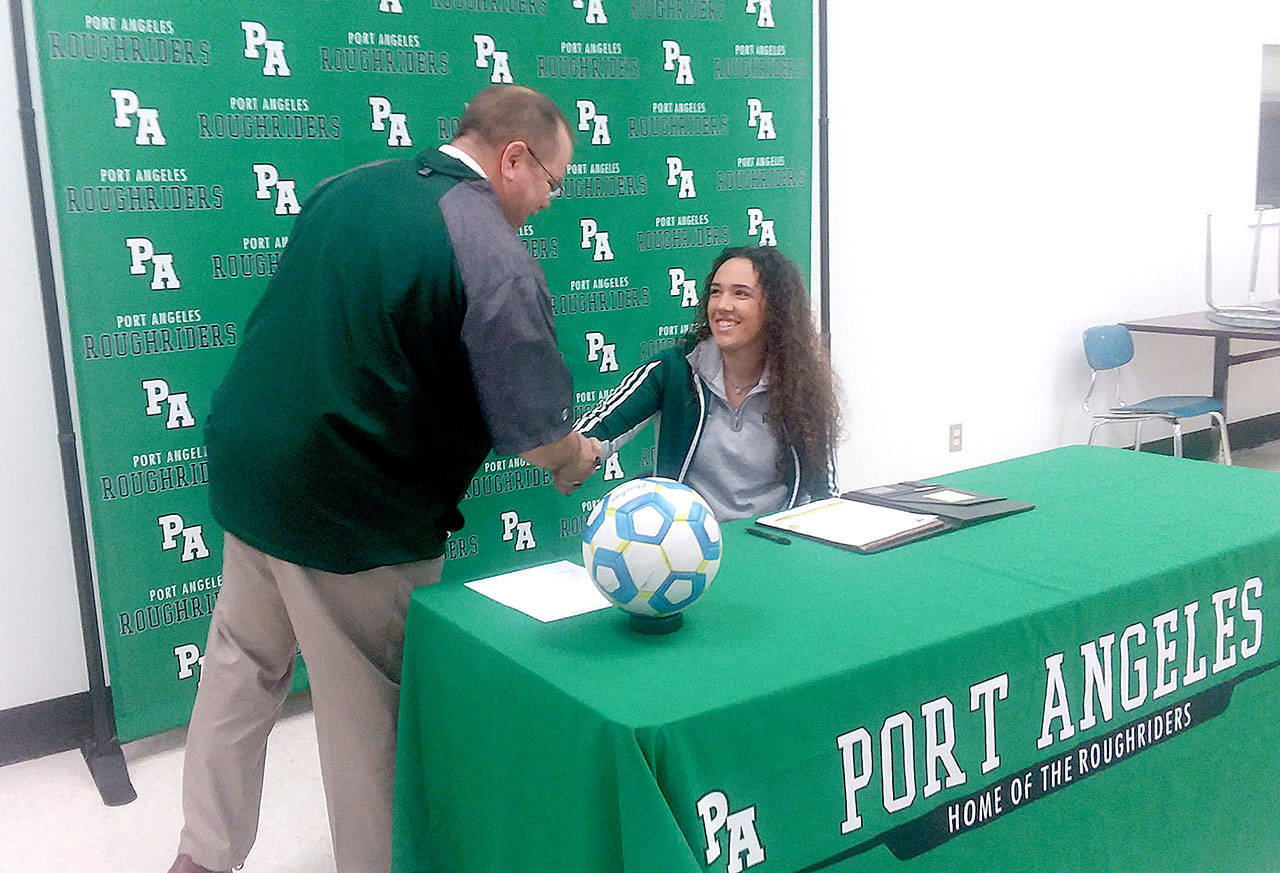 Port Angeles’ Lucah Folden is congratulated by Port Angeles Athletic Director Dwayne Johnson after signing to play soccer for Edmonds Community College. (Pierre LaBossiere/Peninsula Daily News)