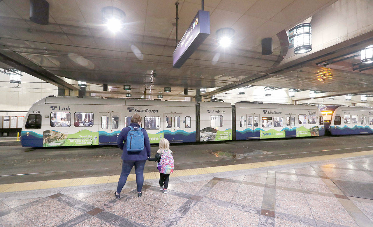 In this Nov. 6, 2019, photo, southbound passengers wait as they look across at a northbound Sound Transit light rail train at an underground station in downtown Seattle. The Washington Supreme Court on Thursday upheld vehicle registration tax increases in the Puget Sound area, a decision that preserves billions of dollars in voter-approved money earmarked for light rail and other projects. (Elaine Thompson/The Associated Press)