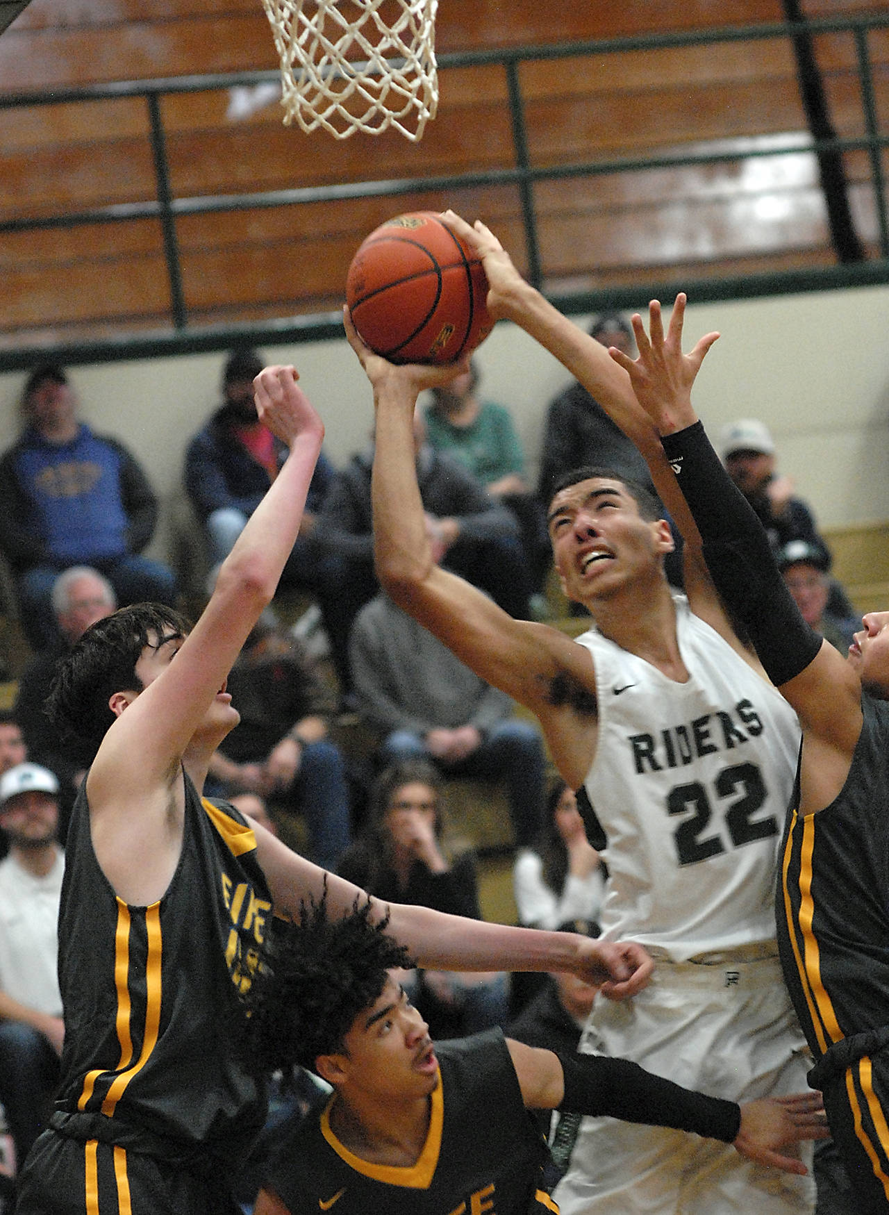 Keith Thorpe/Peninsula Daily News Port Angeles’ Damen Ringgold, center, aims for the hoop surrounded by the Fife defenders, from left, Ivan Gonzalez-Cortez, Khalil Messiah and Braxton Dizon during Thursday night’s playoff game at Port Angeles High School.