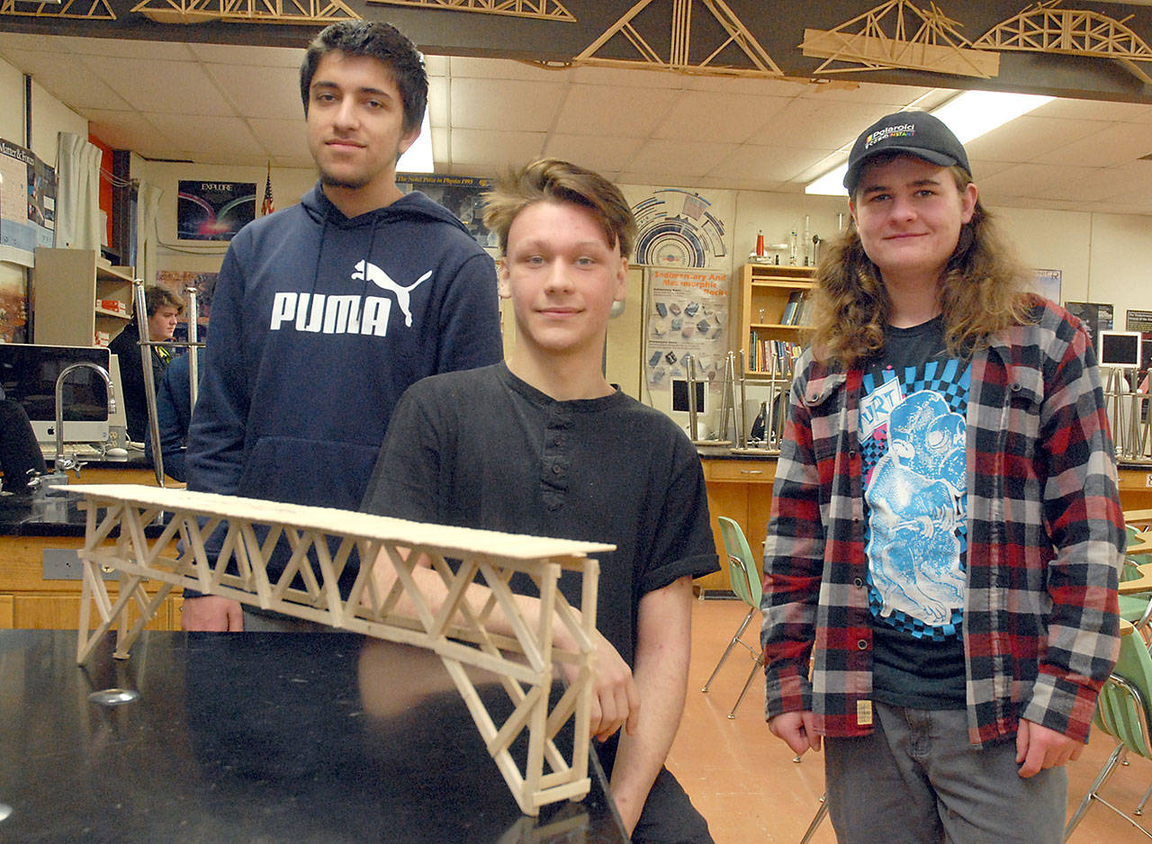 An “unofficial” bridge built by Port Angeles High School students, from left, Areeb Altaf, Andrew Baker and Gunnar Peterson withstood a weight of 210 lbs. (Keith Thorpe/Peninsula Daily News)