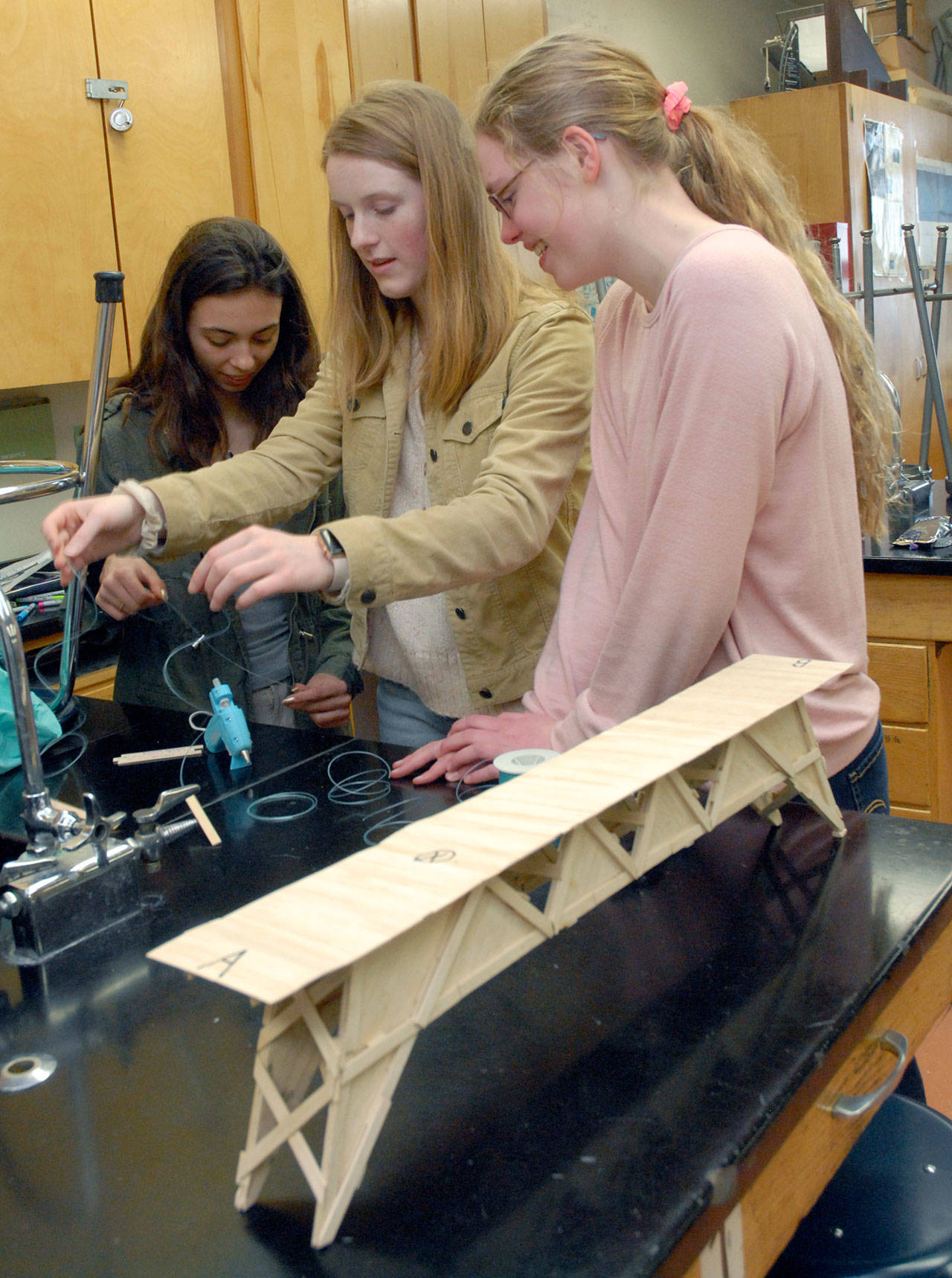 Student bridgebuilders, from left, Kynzie Deleon, Emily Sirgiuy and Emma Weller work to rebuild a portion of their bridge on Wednesday after it cracked under the weight of a 273 lb. press during competition on Feb. 8. (Keith Thorpe/Peninsula Daily News)