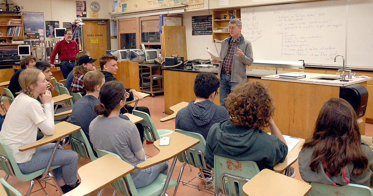 Popsicle bridge advisor Gene Unger of Gene Under Engineering reads off scholarship awards on Wednesday to winning teams in th 2020 Popsicle Bridge Competition. Clallam County assistant engineer Joe Donisi, who helped students with their designs, look on at left. (Keith Thorpe/Peninsula Daily News)