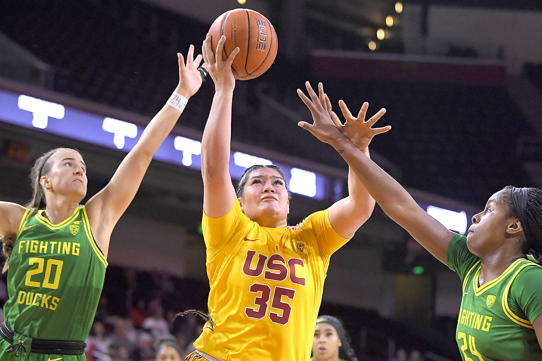 USC forward Alissa Pili, center, shoots as Oregon guard Sabrina Ionescu, left, and forward Ruthy Hebard defend Sunday in Los Angeles. (The Associated Press)