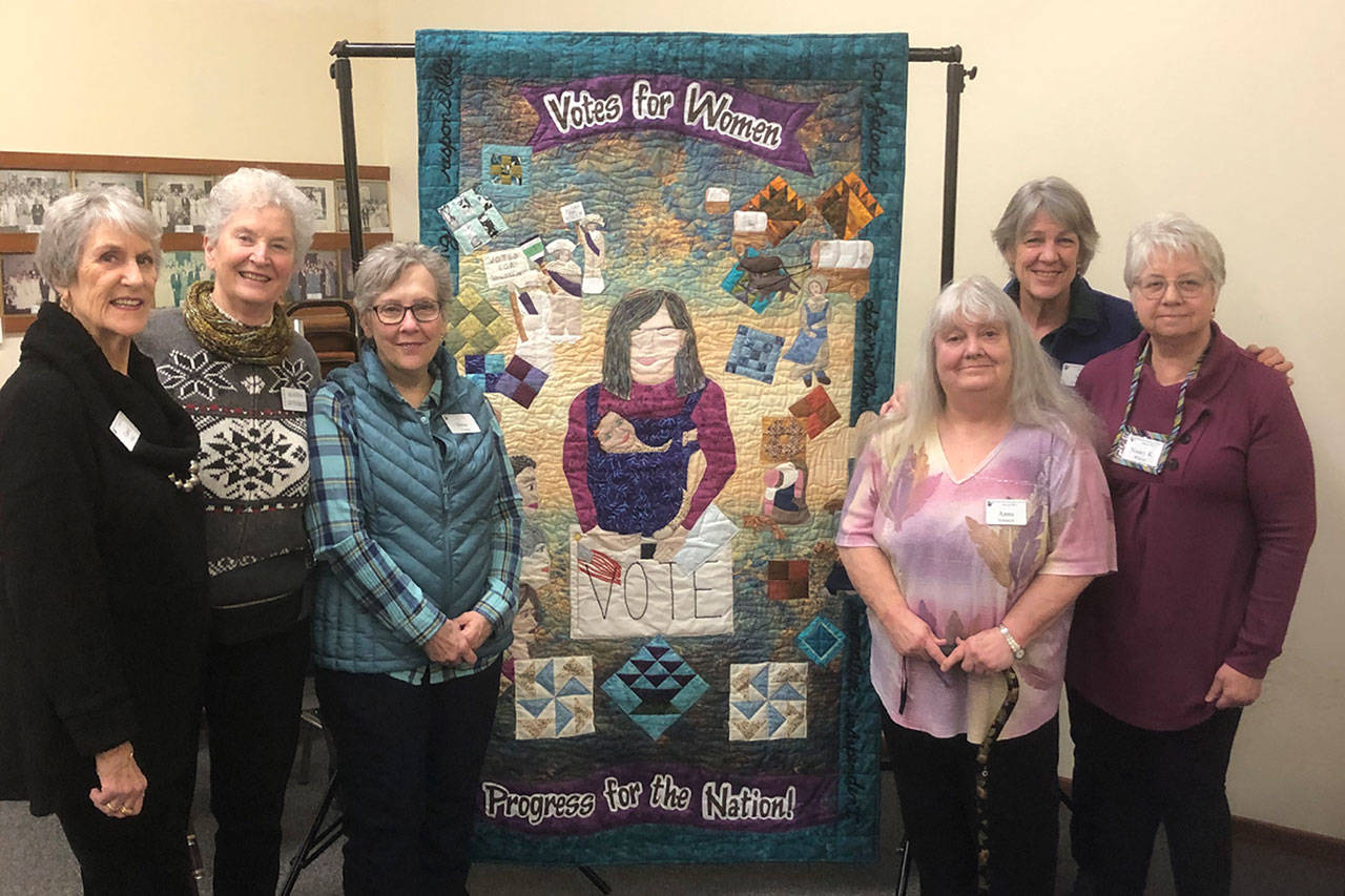 Quilters with the Sunbonnet Sue Quilt Club, from left, Carol Geer, Alanna Levesque, Deni Young, Anna Schenck, Sue Stednick, and Nancy Wilcox, with Norma Herbold not pictured, worked together to create a quilt focusing on women’s right to vote. It’s a collaboration piece with the League of Women Voters to commemorate the 100th anniversary of women’s right to vote. (Photo courtesy of Sue Stednick)