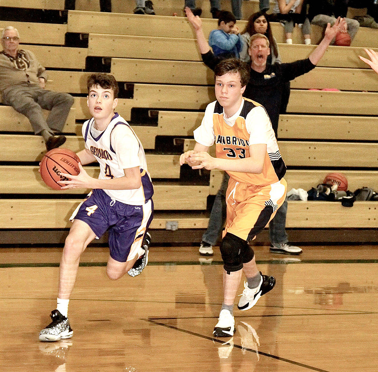 Keenan Green of the Sequim eighth-grade basketball team goes around a Bainbridge Root defender at the President’s Day Classic this weekend. The two-day tournament for boys and girls hosted 56 teams, including a team from Victoria, B.C. (Dave Logan/for Peninsula Daily News)