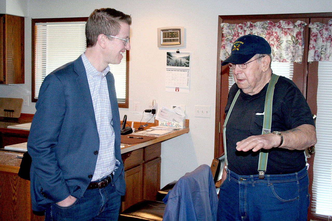Congressman Derek Kilmer, left, visits with Dave Thomas, 85, of Port Townsend after he delivered him a bag of supplies from the Meals on Wheels program. Kilmer, D-Gig Harbor, said President Donald Trump’s proposed budget cuts three programs that social services such as Meals on Wheels rely on to help fill gaps in funding. (Brian McLean/Peninsula Daily News)