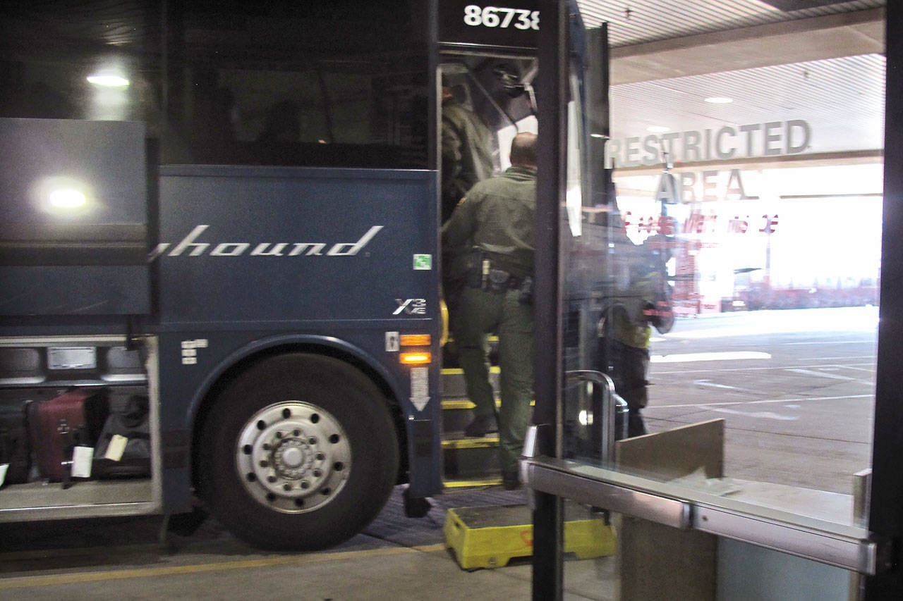 Agents for Customs and Border Protection board a Greyhound bus headed for Portland, Ore., at the Spokane Intermodal Center, a terminal for buses and Amtrak, in Spokane on Feb. 13. (Nicholas K. Geranios/The Associated Press)