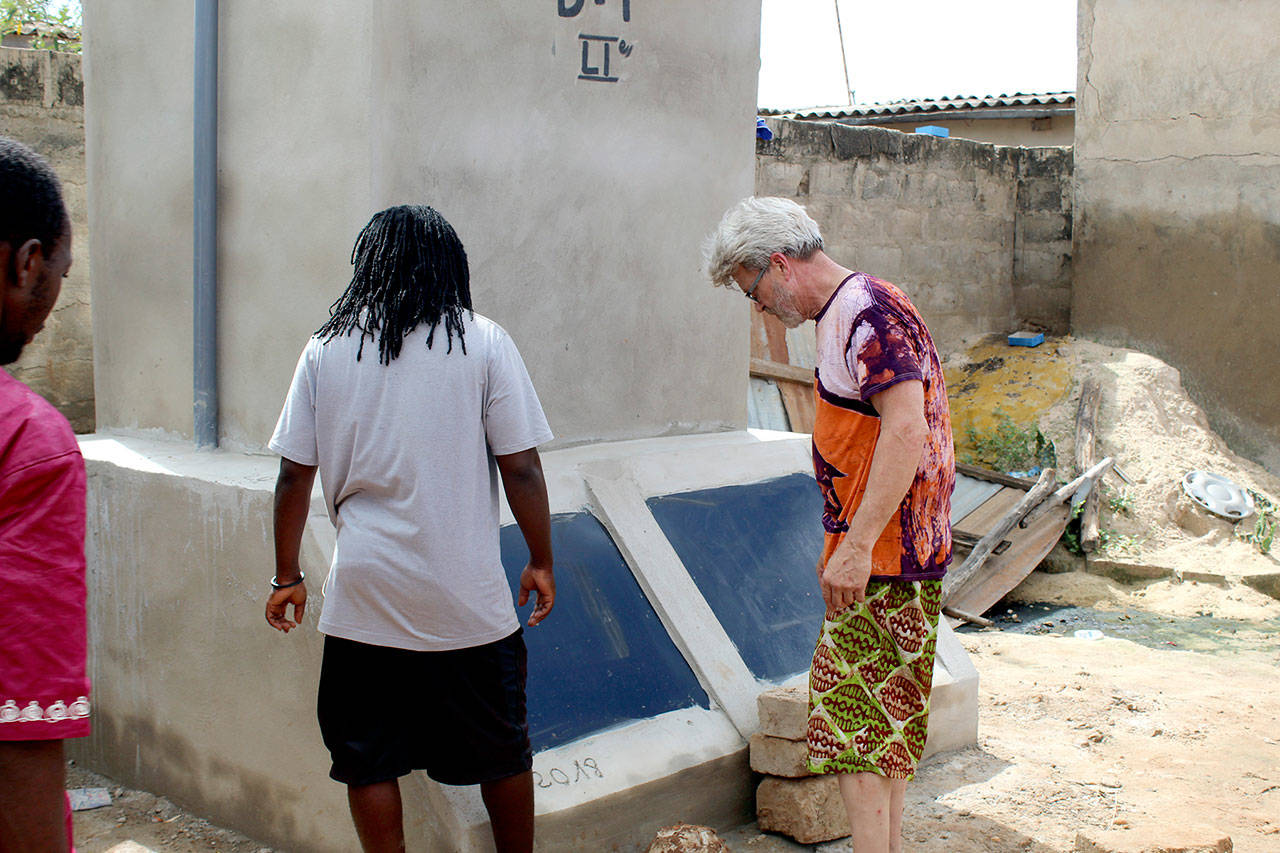 Doc Reiss, left, inspects one of the Dignity toilets that he helped install in Togo, Africa. (Nor’Wester Rotary)