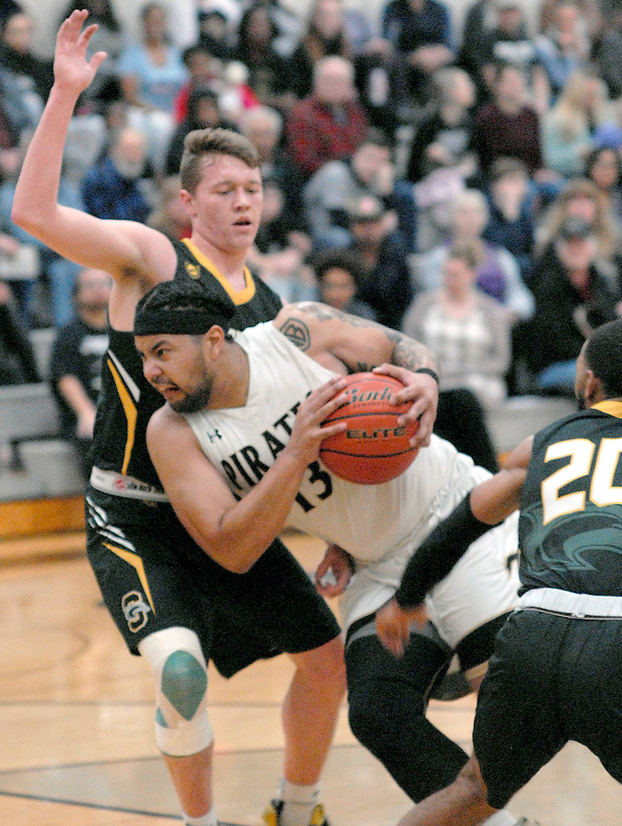 Peninsula’s Marquis Gurske, front, pushes around the defense of Shoreline’s David Perkins during Wednesday’s NWAC North Division game in Port Angeles. Looking on at right is Shoreline’s Keilyn Myers. (Keith Thorpe/Peninsula Daily News)