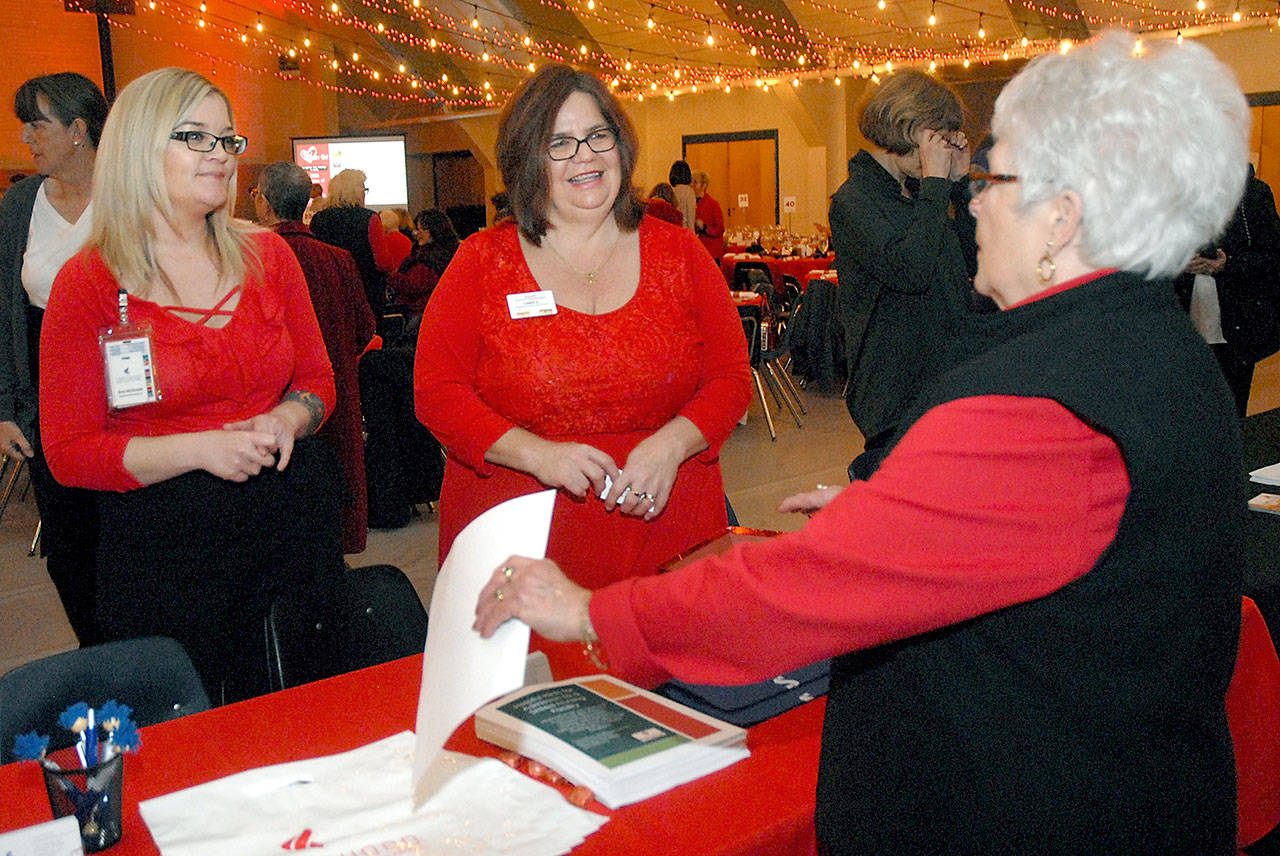 Sherry Phillips of Sequim, right, speaks with Amy McDonald of Crestwood Health and Rehabilitation of Port Angeles, left, and Cindy Kazlauskas of Sequim Health and Rehabilitation during Friday’s 13th annual Red! Set! Go! Heart Luncheon at Vern Burton Community Center in Port Angeles. (Keith Thorpe/Peninsula Daily News)