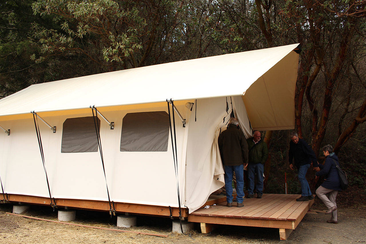 Members of the Friends of Fort Worden, the Fort Worden Public Development Authority and the Fort Worden Coordinating Committee enter a glamping tent. (Zach Jablonski/Peninsula Daily News)