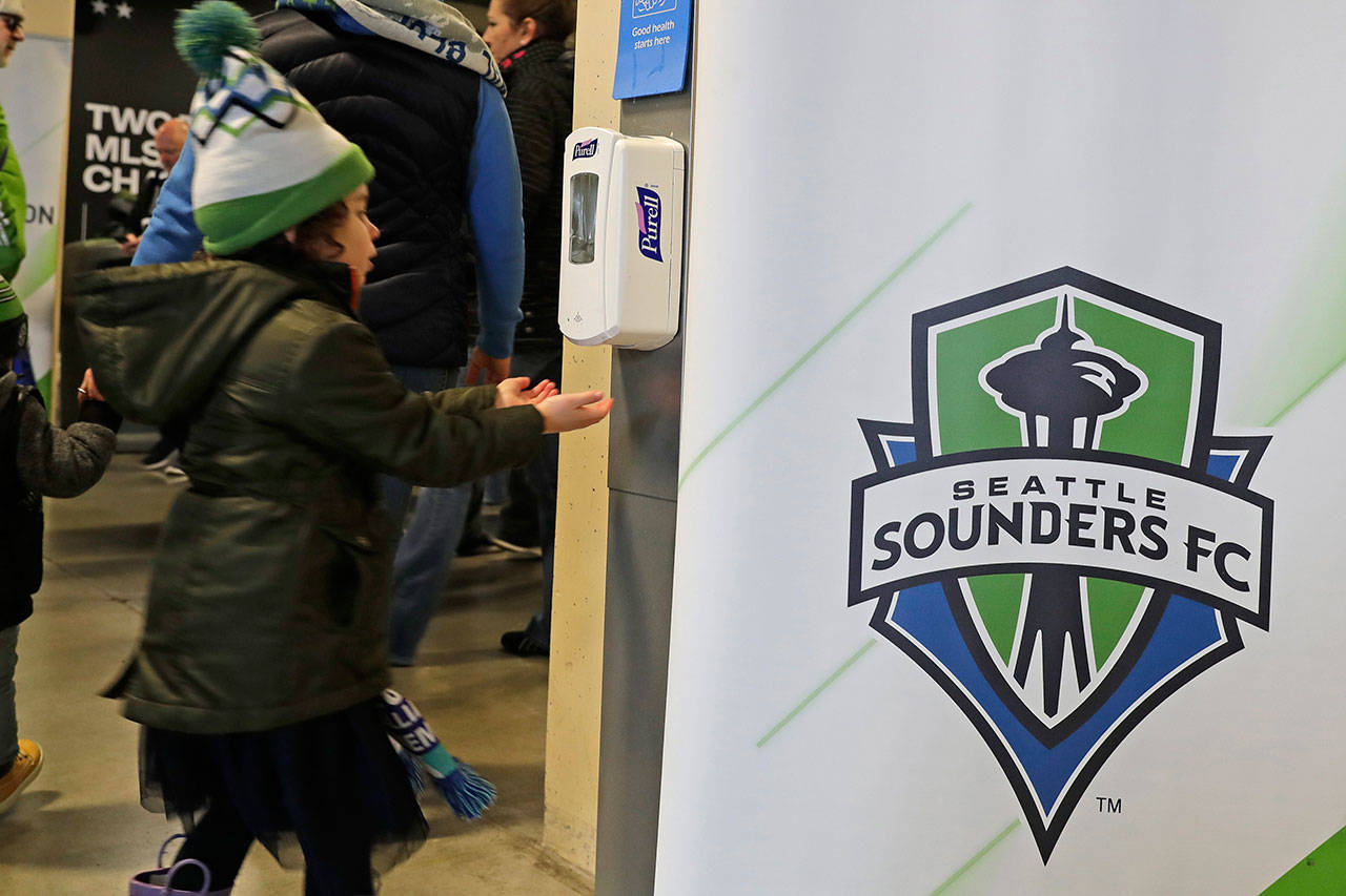 A young fan makes use of a hand-sanitizing station at CenturyLink Field prior to an MLS soccer match between the Seattle Sounders and the Chicago Fire on Sunday in Seattle. (Ted S. Warren/The Associated Press)