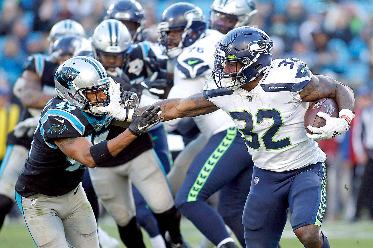 Seattle Seahawks running back Chris Carson (32) runs while Carolina Panthers defensive back Ross Cockrell (47) chases during the second half of an NFL football game in Charlotte, N.C., Sunday, Dec. 15, 2019. (Brian Blanco/The Associated Press)