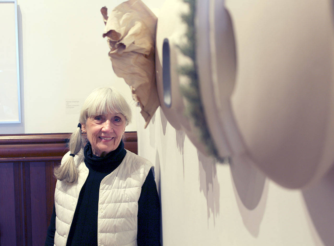 Port Townsend artist and potter Anne Hirondelle stands next to her “Portraits,” pieces that combine stoneware and other natural materials such as lichen and horsehair. The pieces are on display at the Jefferson Museum of Art & History and are part of Hirondelle’s “Not Done Yet” exhibit. (Zach Jablonski/Peninsula Daily News)