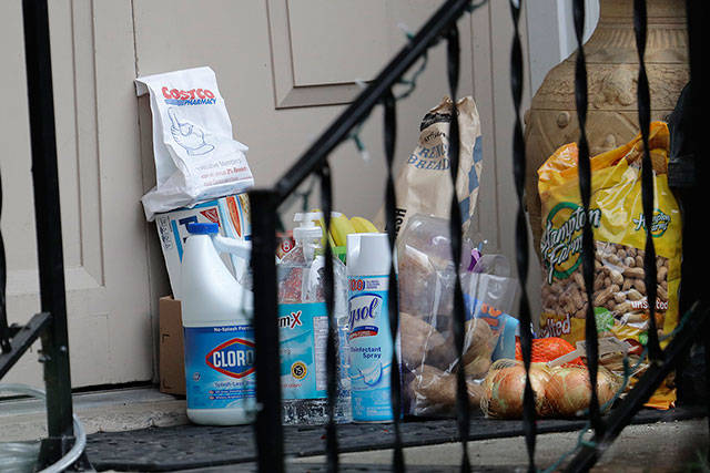 Groceries, cleaning supplies, prescription medicine, and other items are shown on the front porch of the home of Bob and Pat McCauley, Friday, March 6, 2020, in Kirkland, Wash. The items were left by their daughter, who is avoiding close contact with her parents since they began being self-quarantined in their home during the past week due to having visited friends at the Life Care Center nursing home — which has become the epicenter of the outbreak of the COVID-19 coronavirus in Washington state — several times in February. (Ted S. Warren/The Associated Press)
