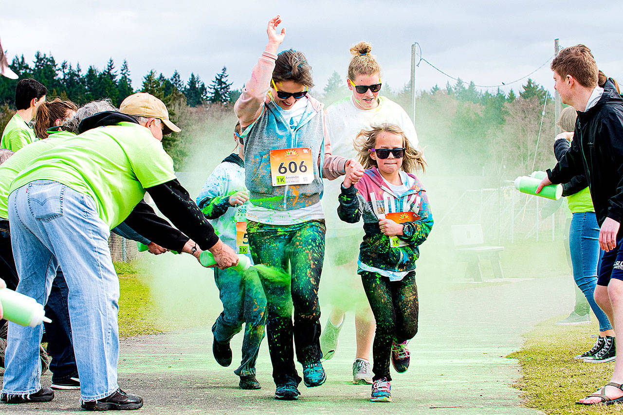 Heart and Passion Films Amanda and Heidi Kiddle of Port Angeles Run through the Green Color Zone at the Sun Fun Color Run on Saturday.