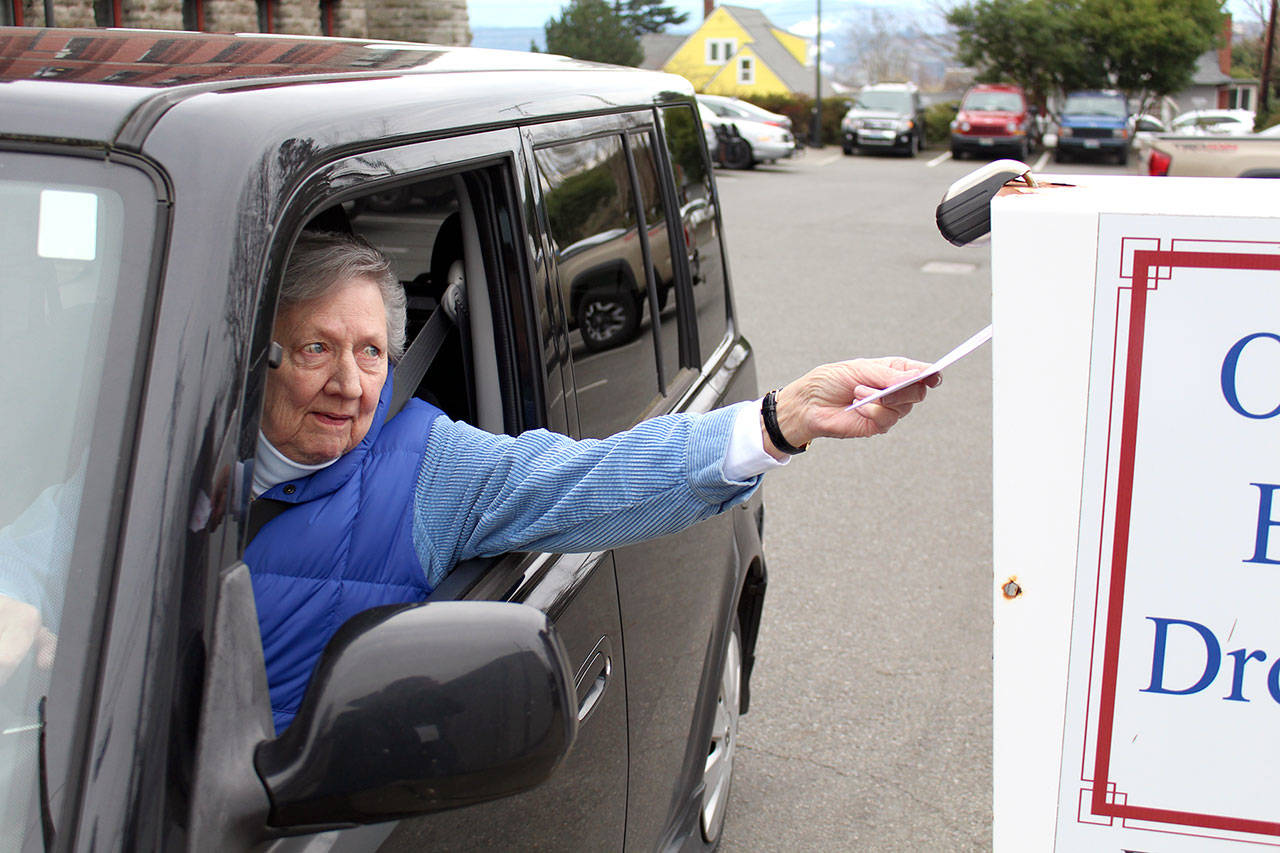 Jefferson County resident Sarah Haull drops off her presidential primary ballot at the ballot drop box behind the Jefferson County Courthouse on Tuesday morning. (Zach Jablonski/Peninsula Daily News)