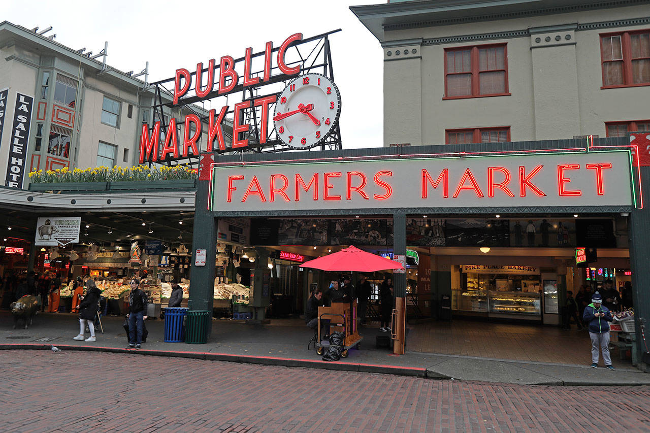 In this March 6, 2020, photo, the area near Pike Place Fish Market at the Pike Place Market in Seattle is nearly devoid of root traffic and crowds at the close of the day. The market, which is popular with tourists and locals alike, has seen crowds thin as some workers stay home and work remotely, and some tourists cancel trips over worry about COVID-19. (Ted S. Warren/The Associated Press)