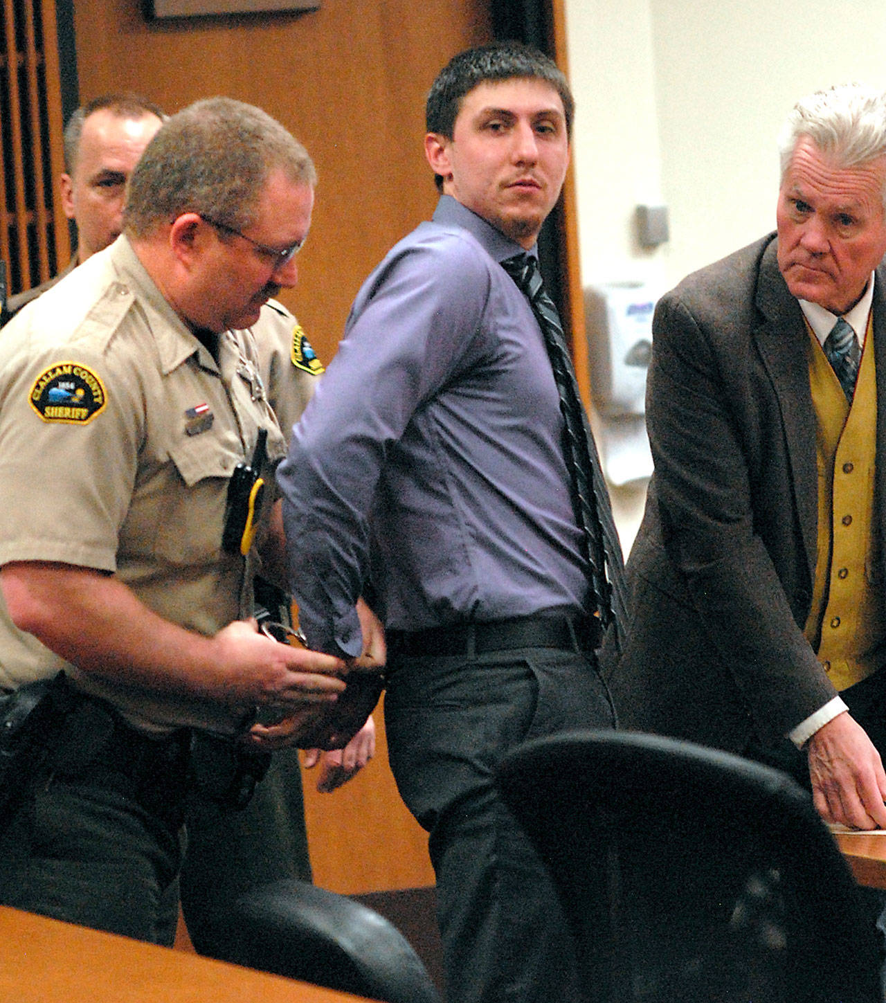 Zachary Alan Fletcher, 23, is handcuffed by Clallam County Corrections Deputy Richard Bray, left, as attorney Lane Wolfley looks on at right after Fletcher was sentenced to 48 months in custody on Wednesday, March 11, 2020, in Clallam County Superior Court on two charges of alcohol-related vehicular assault. (Keith Thorpe/Peninsula Daily News)