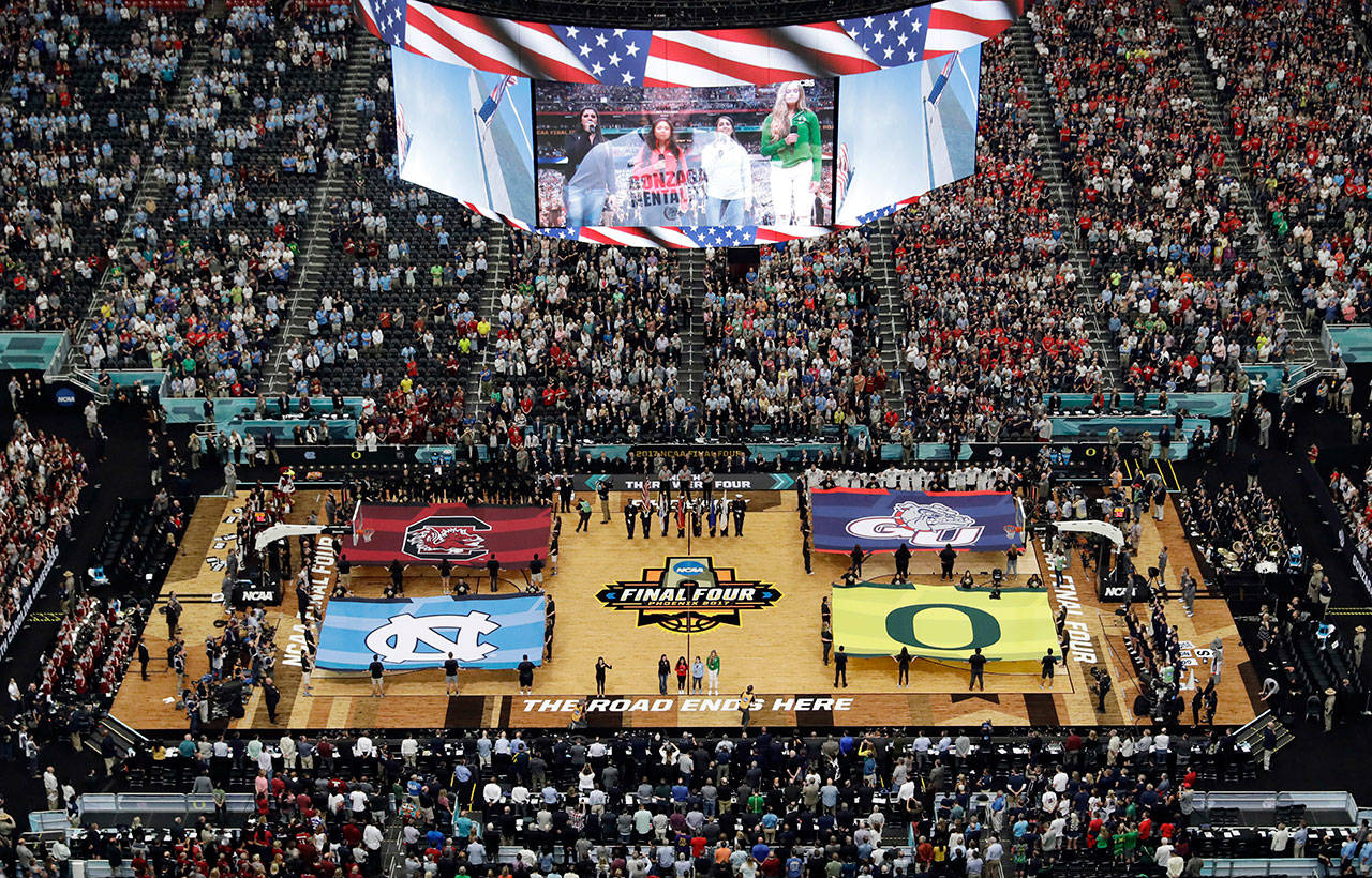In this April 1, 2017, file photo, fans stand as they observe the national anthem before the Final Four in the NCAA college basketball tournament in Glendale, Ariz. NCAA President Mark Emmert says NCAA Division I basketball tournament games will be played without fans in the arenas because of concerns about the spread of coronavirus. (Morry Gash/The Associated Press file)