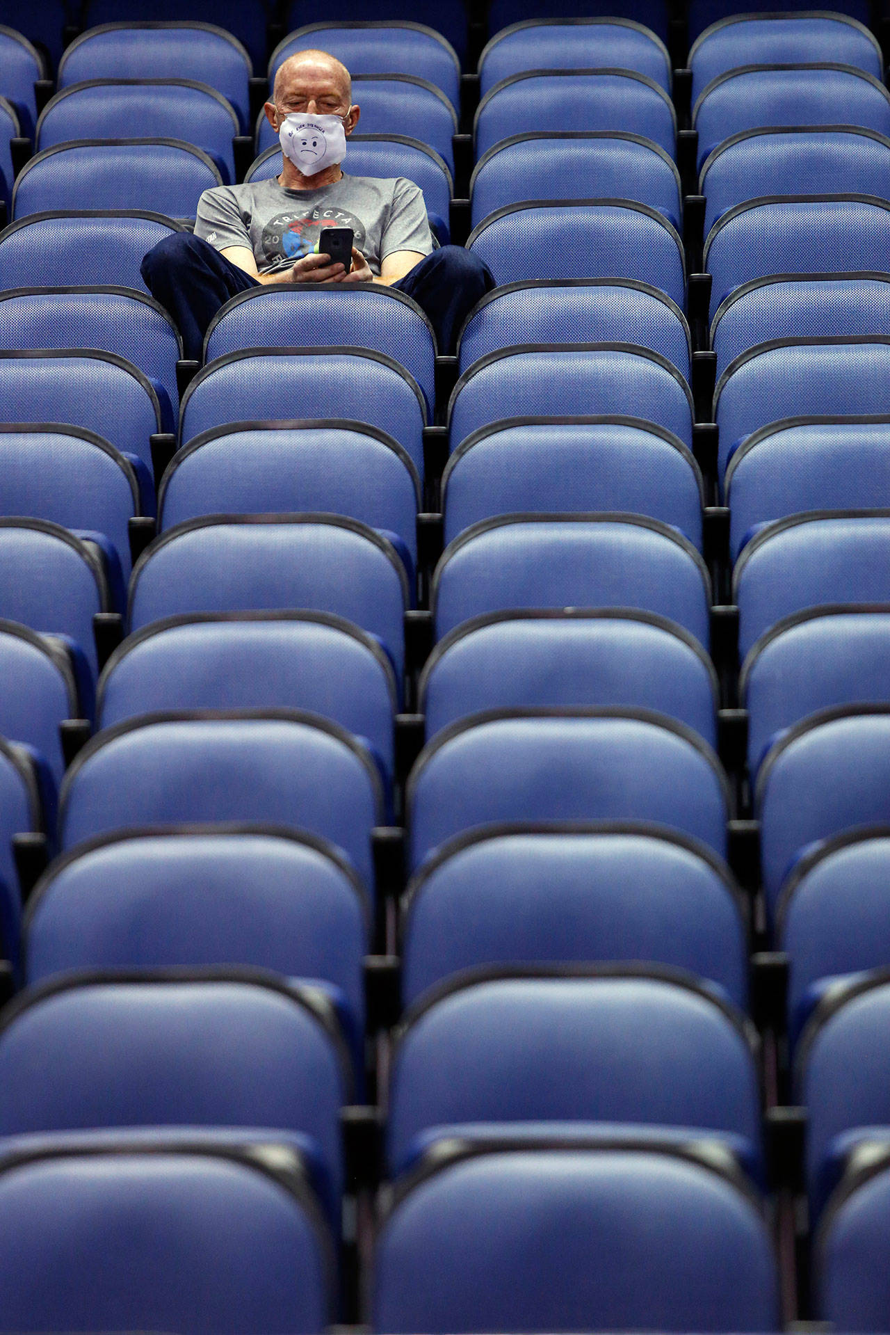 Mike Lemcke from Richmond, Va., sits in an empty Greensboro Coliseum after the NCAA college basketball games were cancelled at the Atlantic Coast Conference tournament in Greensboro, N.C., on Thursday, March 12, 2020. The biggest conferences in college sports all canceled their basketball tournaments because of the new coronavirus, seemingly putting the NCAA Tournament in doubt. (Ben McKeown/The Associated Press)